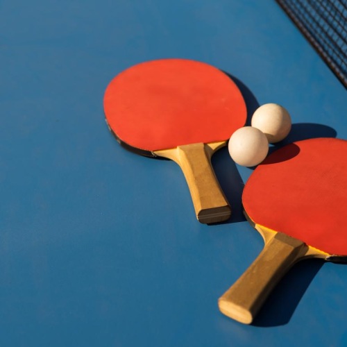 a ping pong table with paddles and balls